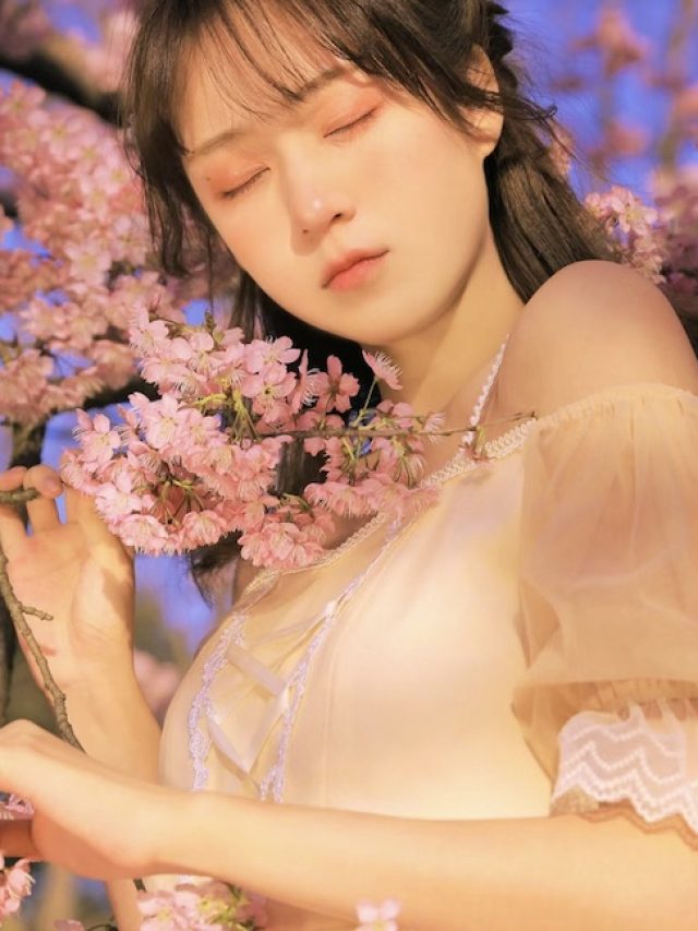 girl posing in front of cherry blossoms